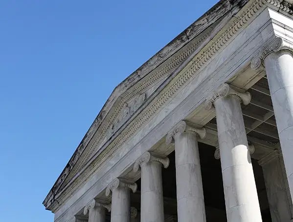 Fotografía de un edificio con columnas de abajo hacia el cielo