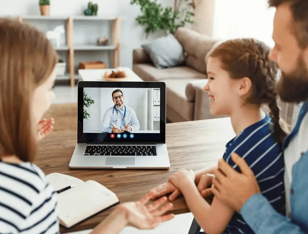 Família em frente ao laptop em teleconsulta com seu médico