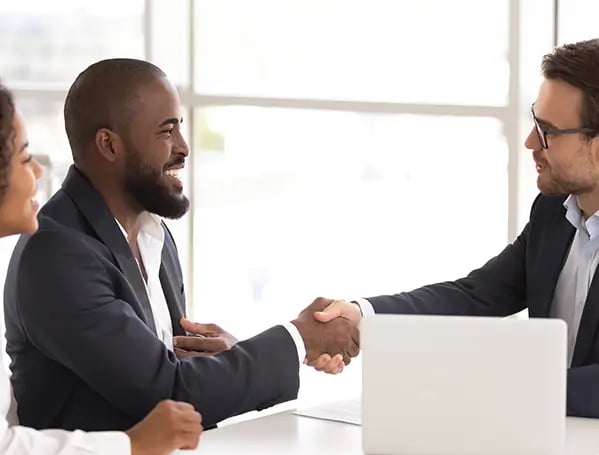 A woman and two men giving his hand closing a deal