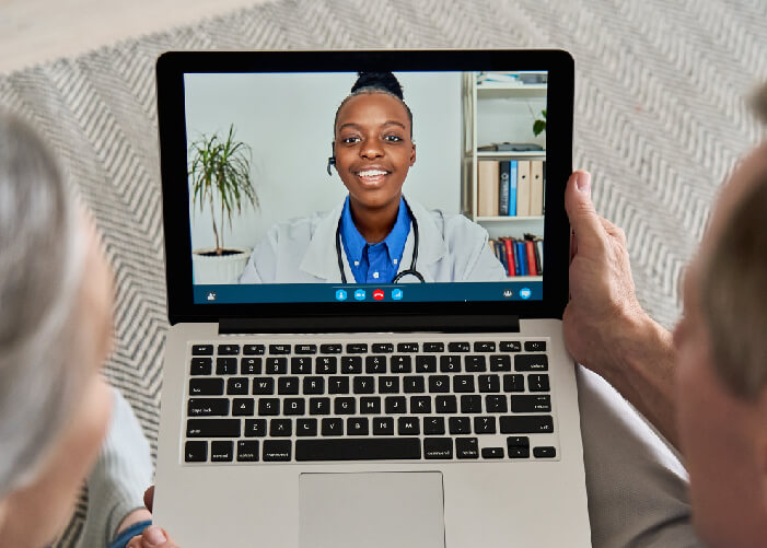 Adultos mayores en consulta de telemedicina con doctora joven