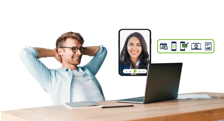 Hombre con gafas recostado sobre sus manos viendo su computadora mientras realiza una videollamada con una ejecutiva virtual
