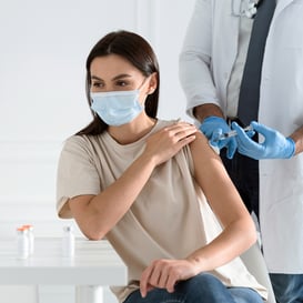 Paciente recibiendo atención médica durante proceso de vacunación COVID en entorno controlado.