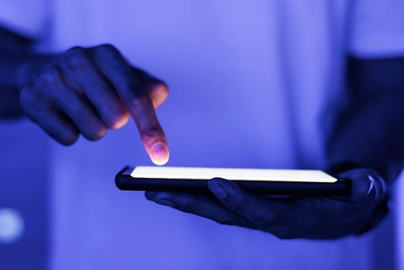 Mano apuntando un celular con la pantalla encendida