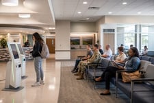 Patients waiting near self-service kiosks in a military medical center.