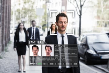 Man walking a sidewalk being recognized through technology that recognizes facial photos
