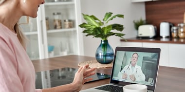 Woman having a telehealth appointment with a  male doctor on laptop