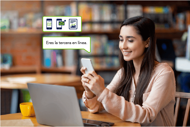 Mujer joven viendo su teléfono mientras espera su turno virtual en una biblioteca