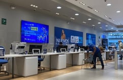 Centro de atención al cliente con personas esperando y siendo atendidas en entorno de telecomunicaciones