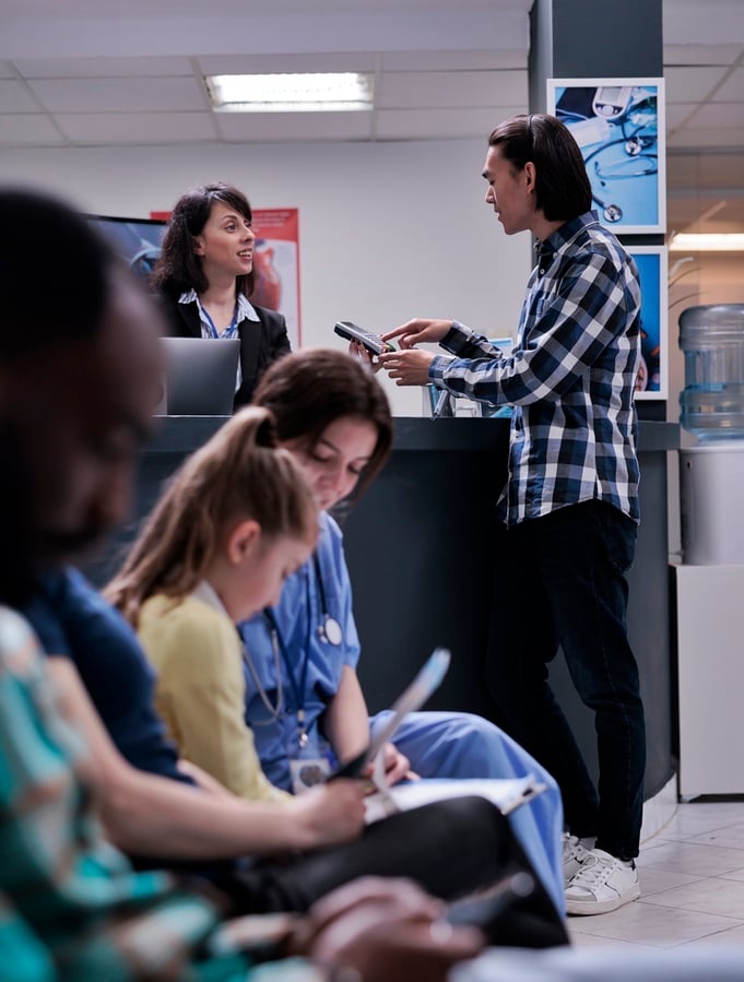 asian-patient-at-hospital-front-desk-paying-at-pos-2025-02-17-19-52-06-utc-1