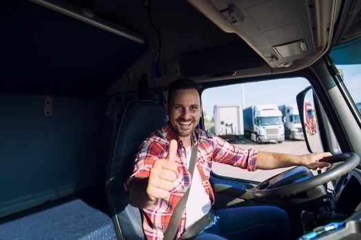 retrato-de-conductor-de-camion-motivado-profesional-sosteniendo-thumbs-up-en-la-cabina-del-camion