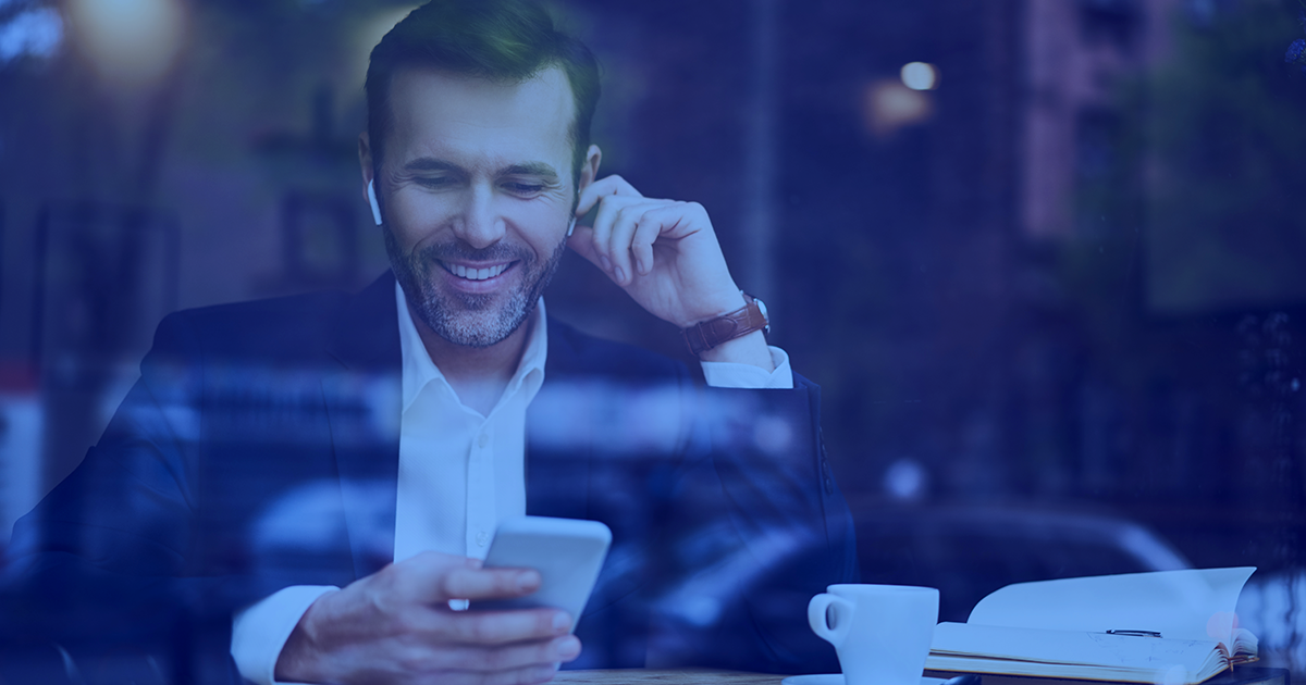 Man sitting in cafe, on phone, making appointment 