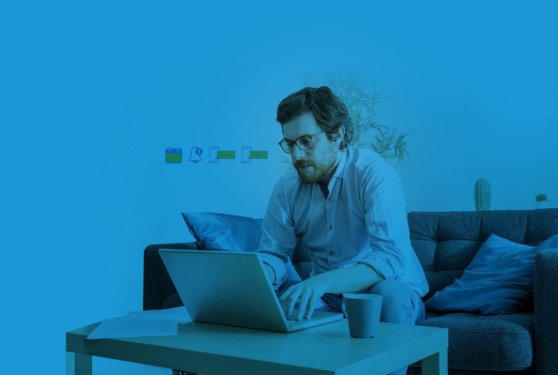 man wearing glasses and working with his computer at his coffee table, user experience related icons appear