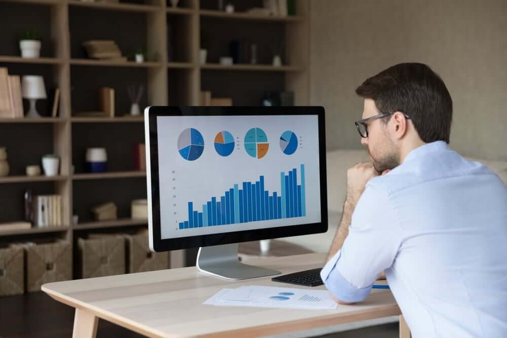 Man at desk looking at computer screen with appointment data