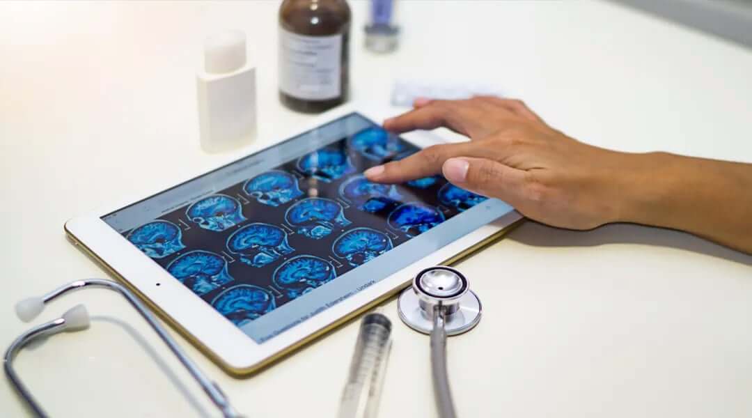 Tablet con imágenes de radiología con una mano presionando la pantalla