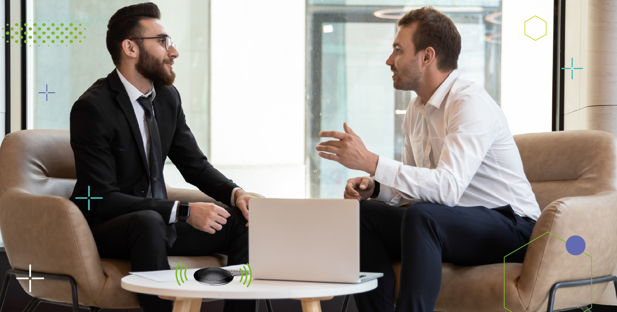 Ejecutivo y cliente interactuando sentados frente a frente, una mesa a una laptop y un micrófono