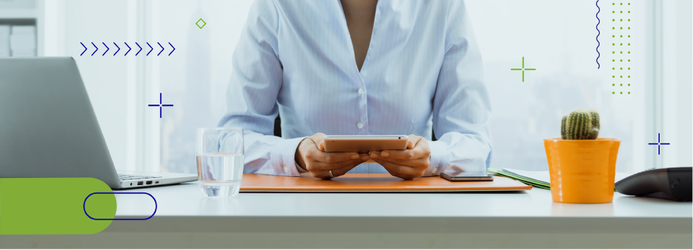 Mujer con camisa blanca sentada en un escritorio utilizando una tableta - ACF