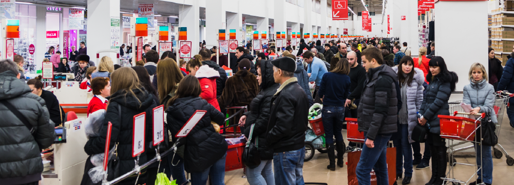 Personas haciendo fila en las cajas de un supermercado