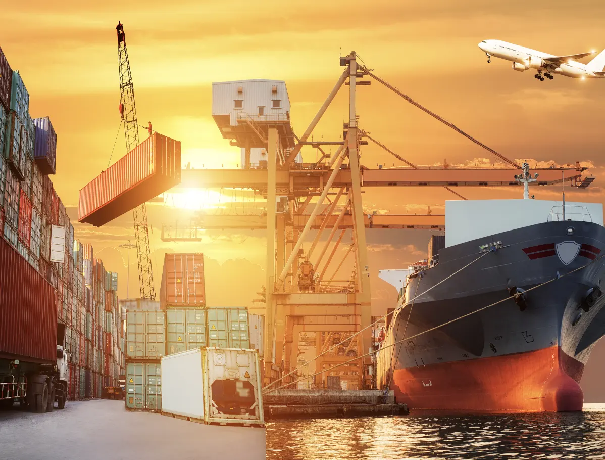 Imagen de un puerto con varios containers, un barco y un avión con un fondo de un atardecer