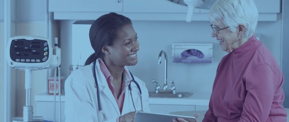 Female doctor smiles at elderly female patient