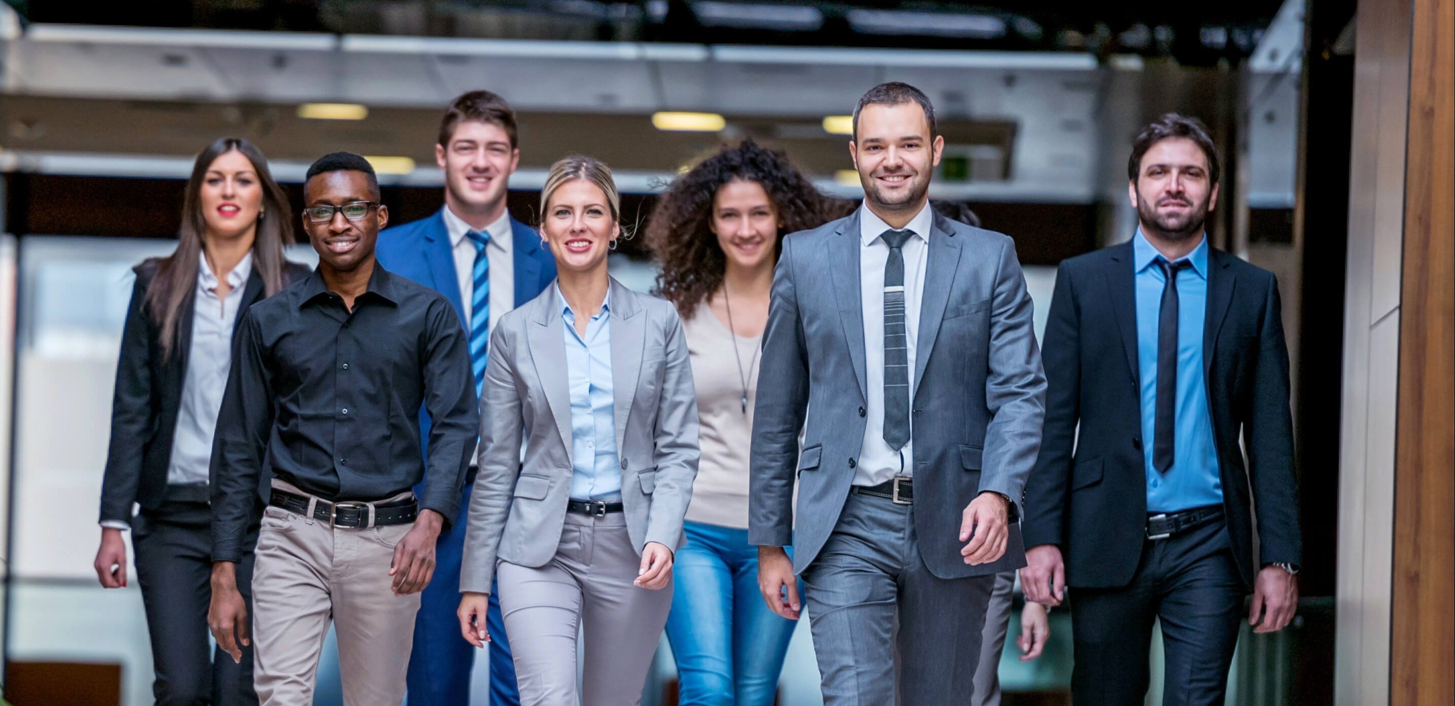 Group of business employees walking forward and smiling