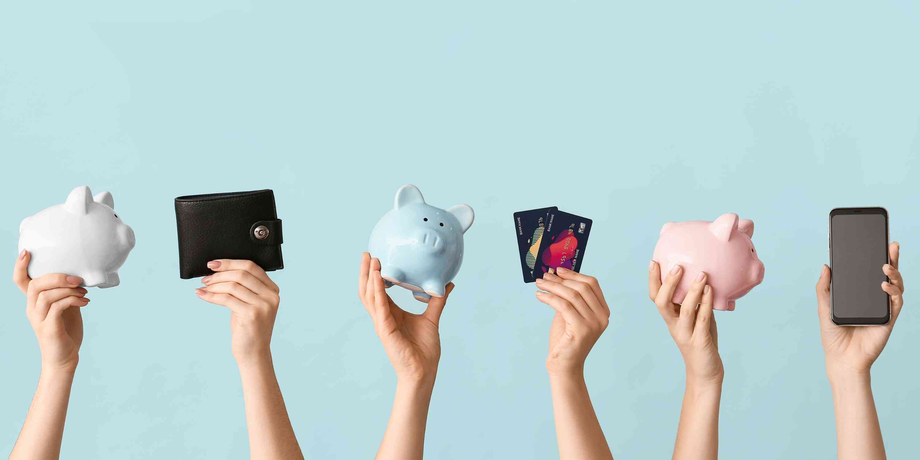 Hands hold up different banking items like wallet, cards and phone.