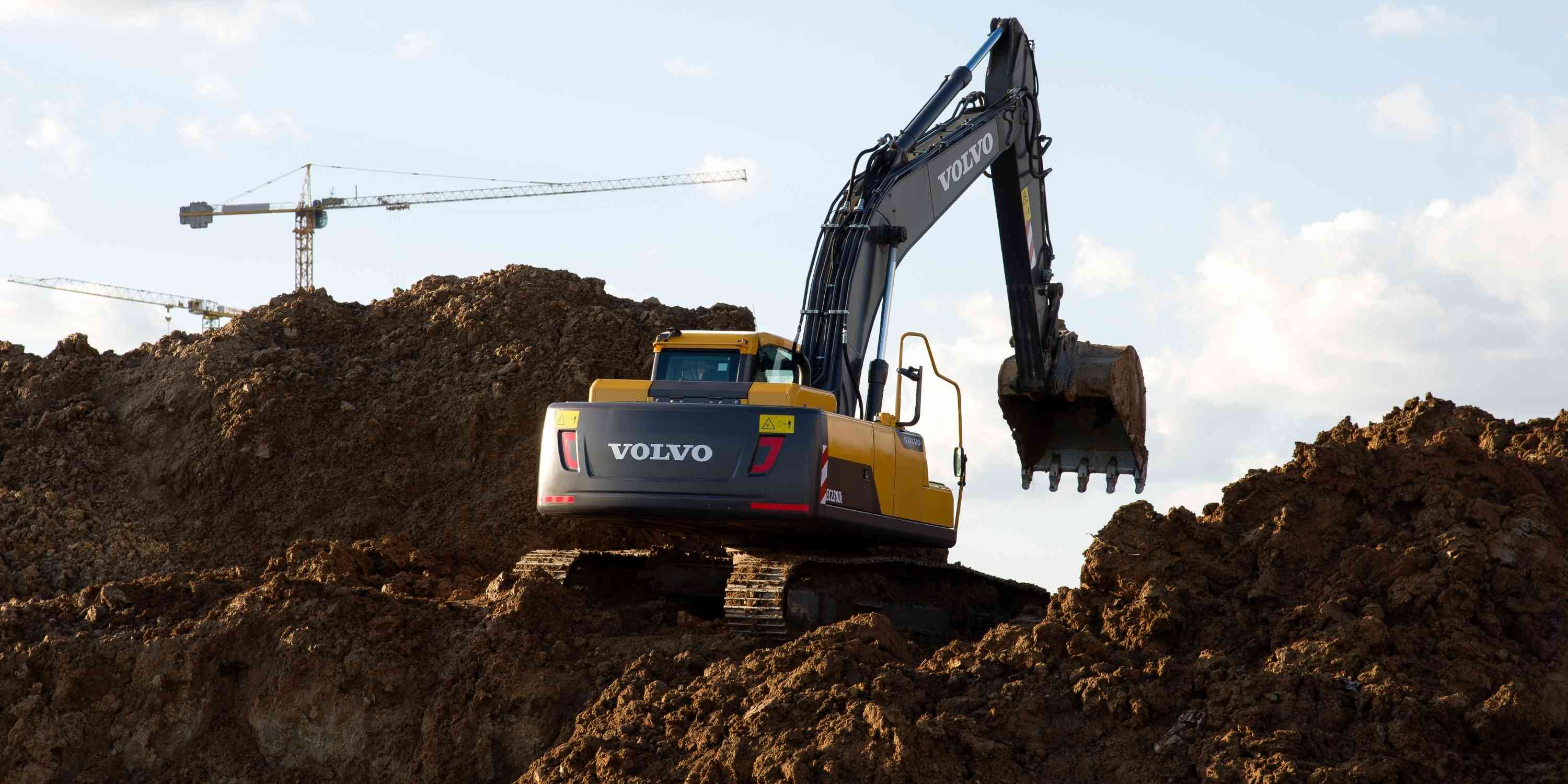 Construction machine digging dirt with Volvo brand label