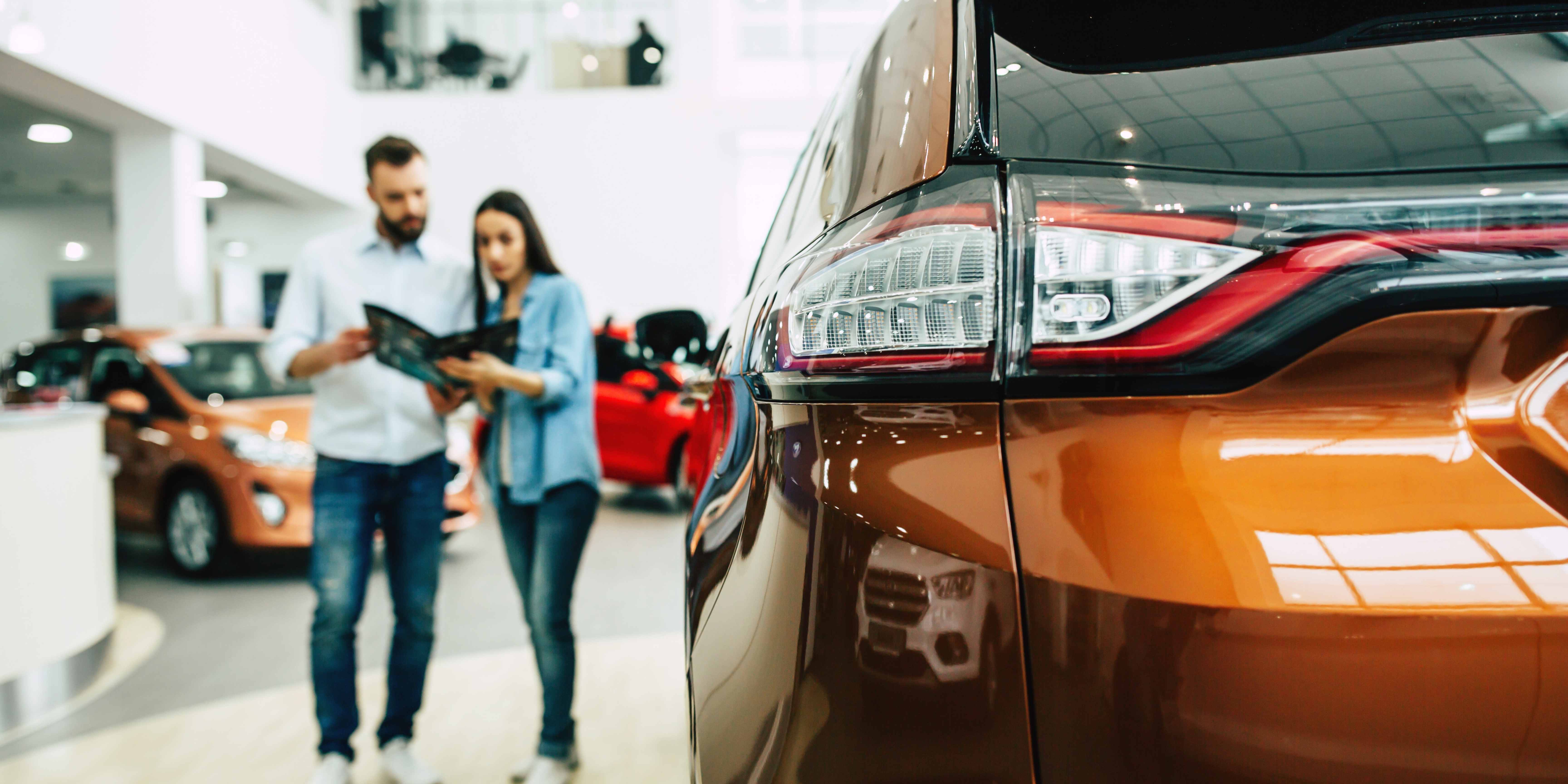 Couple looking at new automobile features or pricing